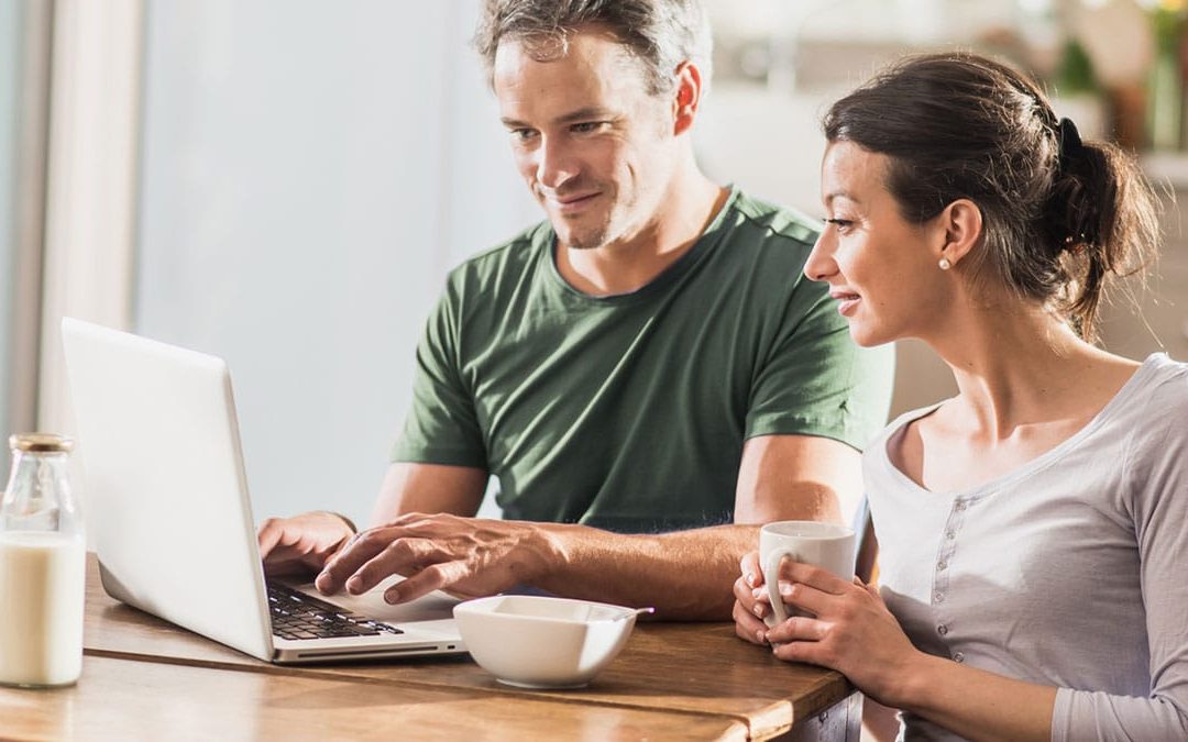 A couple using a laptop at home